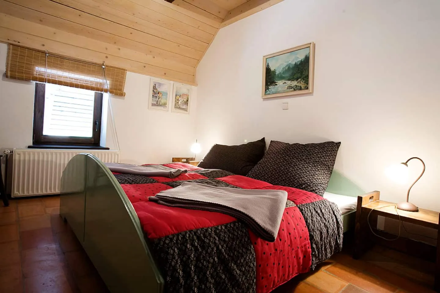 Spalnica zgornjega desnega apartmaja z zakonsko posteljo in rdečo posteljnino